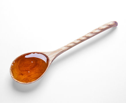 wooden spoon and honey isolated on white background