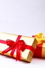 Gift boxes with bow. Colored presents wrapped with paper and ribbons. Christmas or birthday packages. Celebration design. On white table.