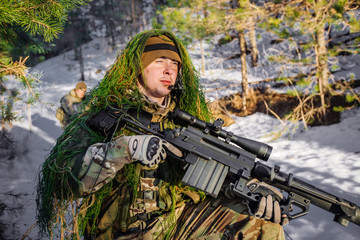 Fototapeta premium team of special forces weapons in cold forest. Winter warfare and military concept