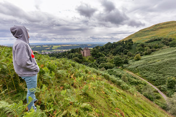 A tourist takes in the hills around Castle Campbell near Dollar, Scotland.