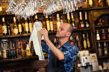 Barman at work in pub,Portrait of cheerful barman worker standing,Waiter giving menus,A pub.Bar.Restaurant.Classic.Evening.European restaurant.European bar.American restaurant.American bar.
