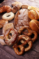 Different kinds of bread and bread rolls on board from above. Ki
