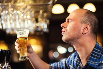 Bartender pouring the fresh beer in pub,barman hand at beer tap pouring a draught lager beer,beer from the tap,Filling glass with beer,fresh beer,pub.Bar.Restaurant.European bar.American bar.