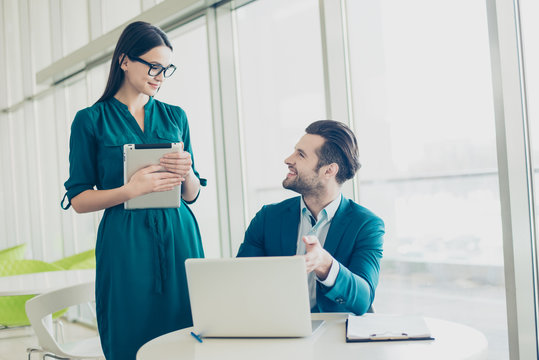 Photo of smiling happy businessman pointing on the screen and secretary listening to the boss