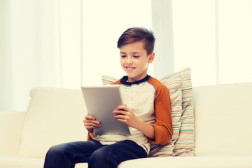 smiling boy with tablet computer at home