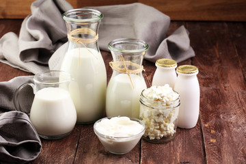 milk products - tasty healthy dairy products on a table on: sour cream in a white bowl, cottage cheese bowl, cream in a a bank and milk jar, glass bottle and in a glass