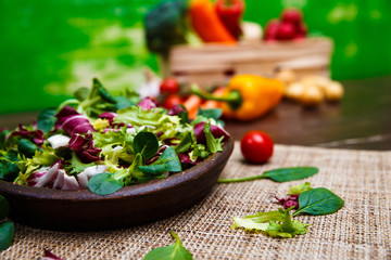 Provence mix salad. Leaves of endive or chicory, lamb and rose salad. Raw vegetables. On wooden table.