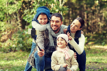Fototapeta premium happy family with smartphone selfie stick in woods