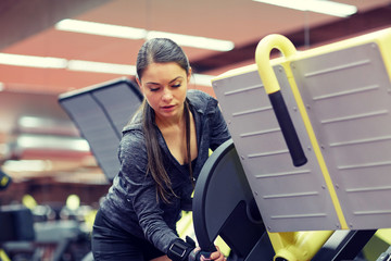 young woman adjusting leg press machine in gym