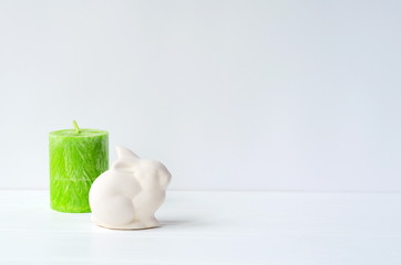 Easter (Ostara, Eoster) bunny with egg shaped candles on white background with copy space