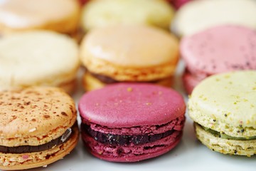 Colorful round macaron cookies on a white platter