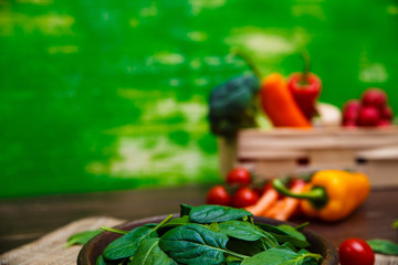 Spinach leaves in bowl. Raw fresh vegetable. Fresh natural plant leaf. Organic bio food on rustic wooden table.