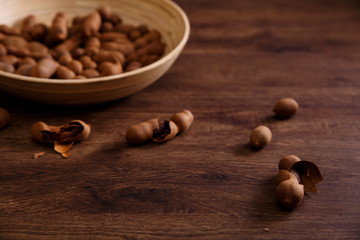 Sweet tamarind on grunge rustic wood background. Natural organic diet food with a lot of vitamins. Plate dish or bowl on wooden board.