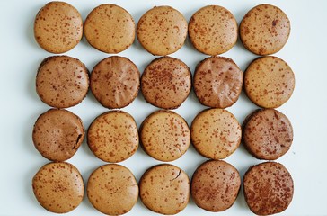 Chocolate round macaron cookies on a white platter