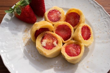 Czech traditional seasonal meal strawberry dumplings with hot dissolved butter and brown cane sugar...