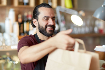 man or waiter with coffee and paper bag at bar