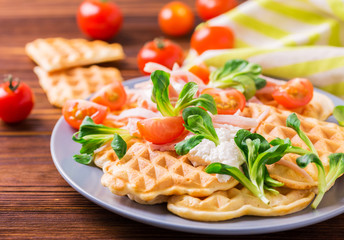Waffles sandwich with bacon, cherry tomatoes and corn salad