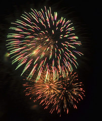 Red, green, and gold fireworks against a black sky