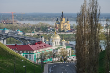 A city landscape with a road, an Orthodox church and bridges in the spring morning. Nizhny Novgorod, Russia