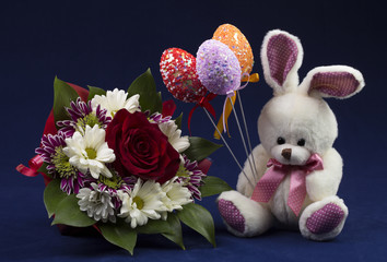 Rabbit and Easter eggs with a bouquet of flowers