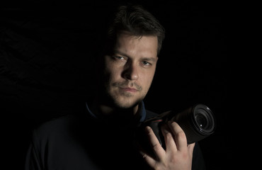 Young man as a photographer portrait isolated on black background