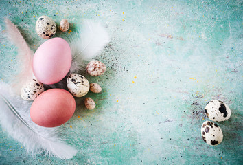 Osterkarte - Rustikaler Hintergrund mit bunten Ostereiern und Federn mit Textfreiraum