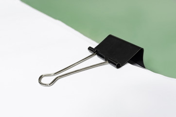 Paper with black clip, office background with selective focus