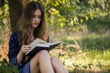 Girl reading book under a tree