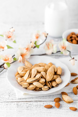 Almond nuts and milk on white background