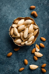 Almond nuts on dark background directly above copy space flat lay