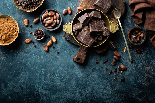 Dark chocolate pieces crushed and cocoa beans, culinary background, top view