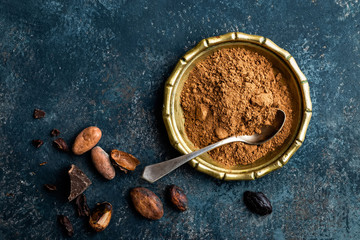 Cocoa powder, beans and dark chocolate pieces crushed, culinary background, top view