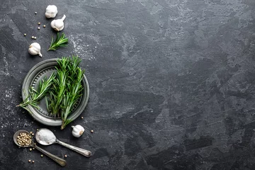 Crédence de cuisine en verre imprimé Herbes Rosemary, garlic, salt and white pepper, culinary background with various spices, directly above, flat lay, copy space