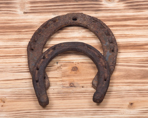 Old rusty vintage good luck horseshoe on wooden tray like background