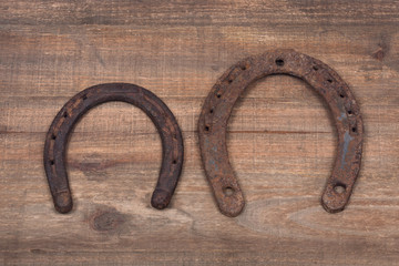 Old rusty vintage good luck horseshoe on wooden tray like background