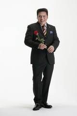 Obraz na płótnie Canvas A man in suit holding a rose
