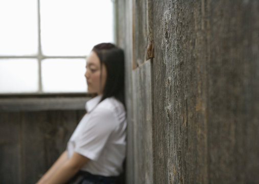Teenage girl leaning against wall
