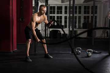 Fototapeta na wymiar Man Using Training Ropes In A Gym