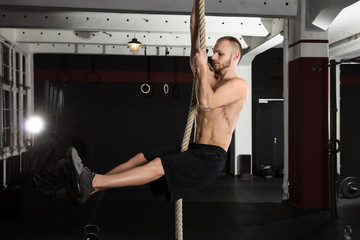 An Athlete Man Climbing On Fitness Rope