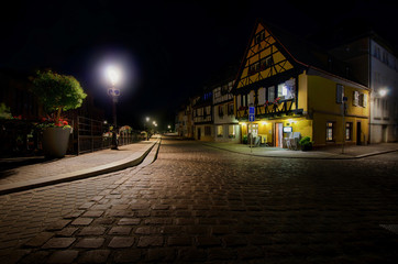 Evening view of old houses in the town of Colmar. Alsace. France.  Street lights are burning.