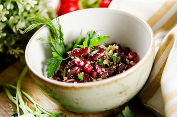 Salad of red beans, walnuts and pomegranate seeds with herbs with light buttery dressing