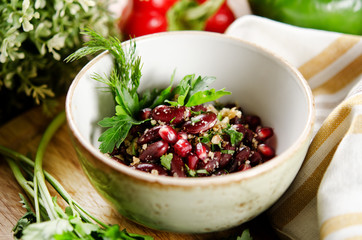 Salad of red beans, walnuts and pomegranate seeds with herbs with light buttery dressing
