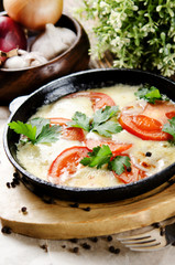 Beef tongue baked with potatoes in creamy sauce with cheese and tomatoes