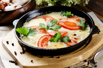 Beef tongue baked with potatoes in creamy sauce with cheese and tomatoes