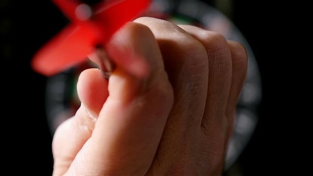 Slow motion of darts player throwing darts,&nbsp;defocused dart board on the background