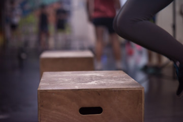 black woman is performing box jumps at gym