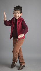 Playful boy isolated on grey background in studio