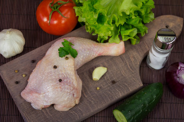 Raw chicken leg on cutting board