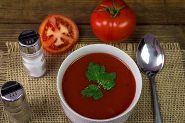Soup tomato in white bowl with parsley and tomatoes