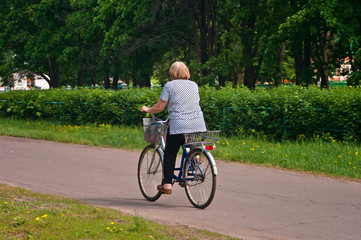 old woman riding a bicycle in the park